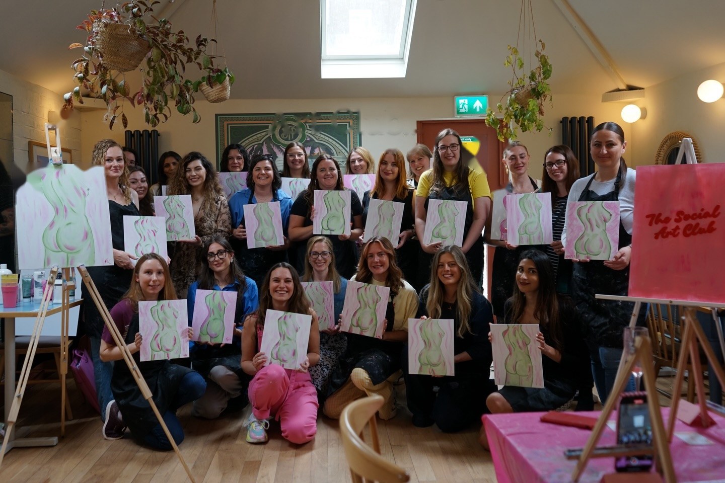 Members holding their paintings at art club